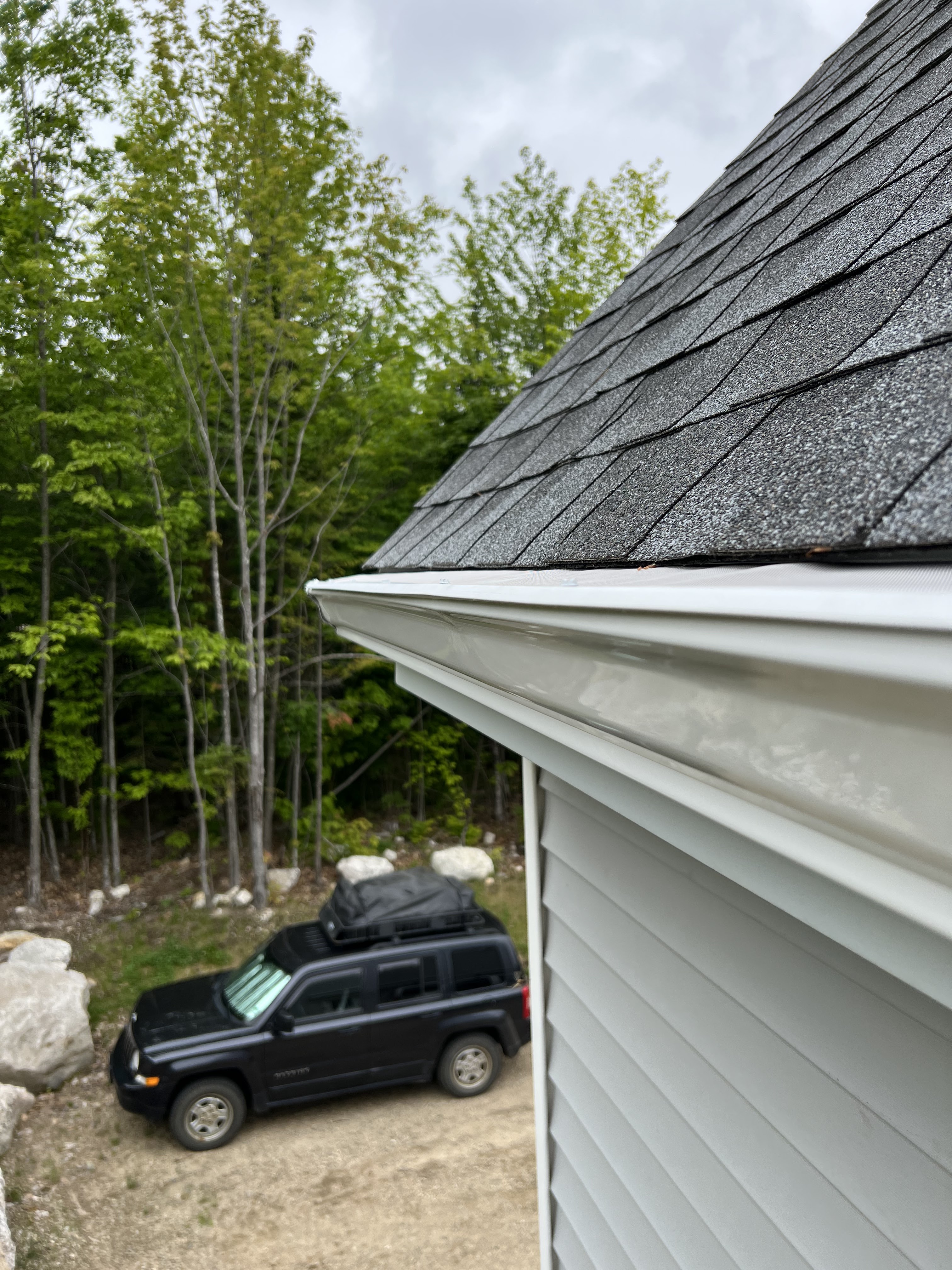 White K-style seamless gutters with New England pine trees in background